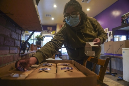 Yajaira Saavedra colocou adesivos com os dizeres La Morada Bx Mutual Aid Kitchen em caixas de comida sendo preparado para distribuição. (Foto: Associated Press/Bebeto Matthews)