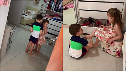 Irmão percebe criança chorando por não querer colocar os sapatos e gentilmente a incentiva a calçá-los.