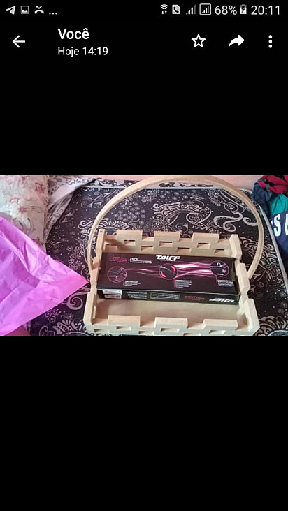 A mulher escondeu o presente numa cesta de chocolate.