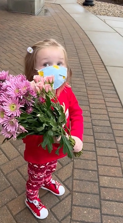 A pequena Olivia segurando o buquê de flores.